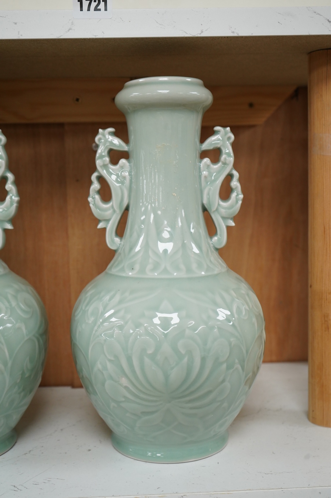 A pair of Chinese celadon glazed vases, decorated in low relief, 32cm high